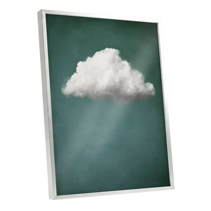 A framed wall art print featuring a single white cloud against a dark teal-green background with soft light rays, shown at an angle with a white frame on a light gray background.