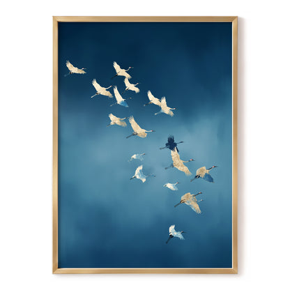 Framed wall art featuring a flock of white cranes flying across a deep blue sky, presented in a light wood frame against a white background.