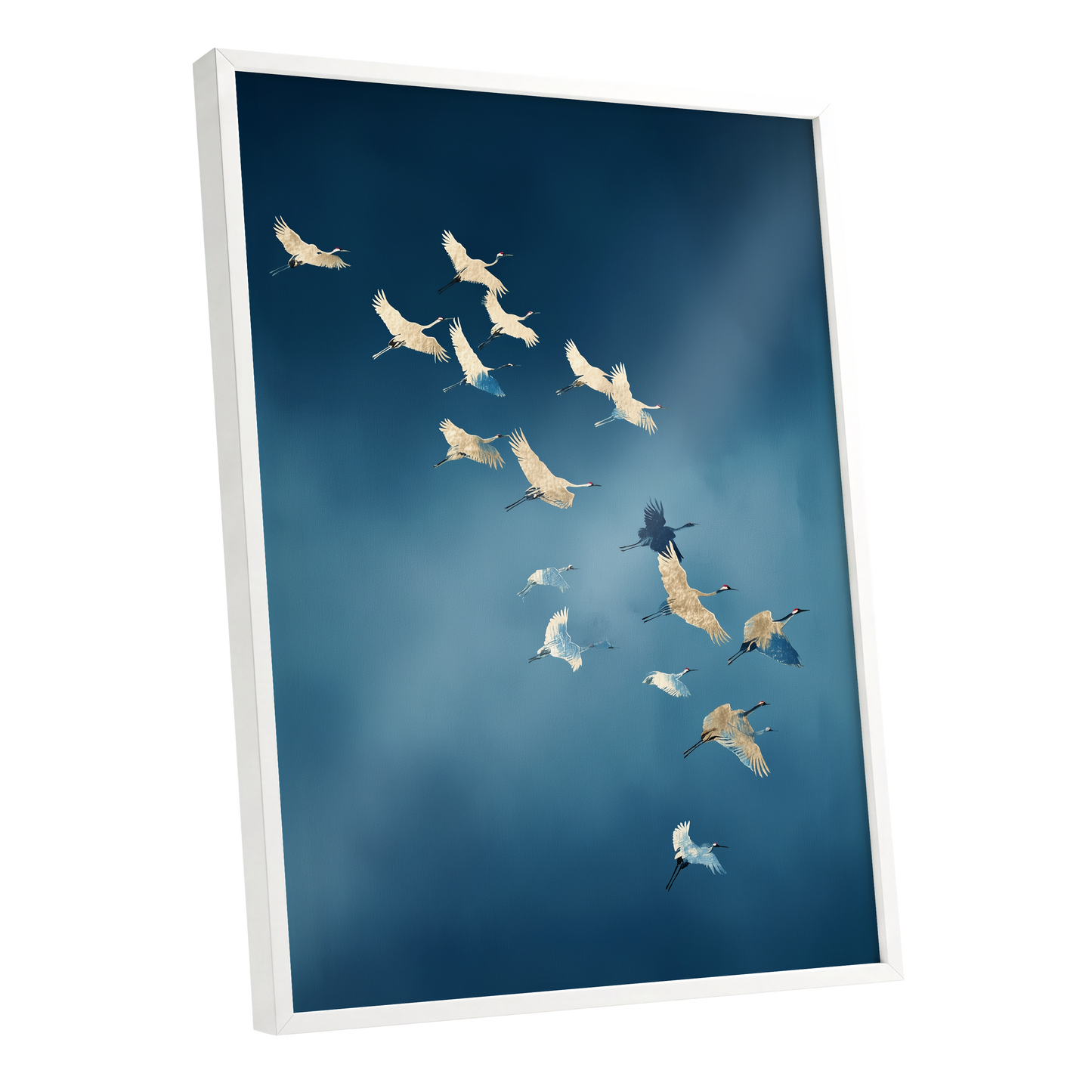 A framed wall art print showing a flock of cranes flying across a deep blue sky, photographed at an angle with a white frame and visible depth.