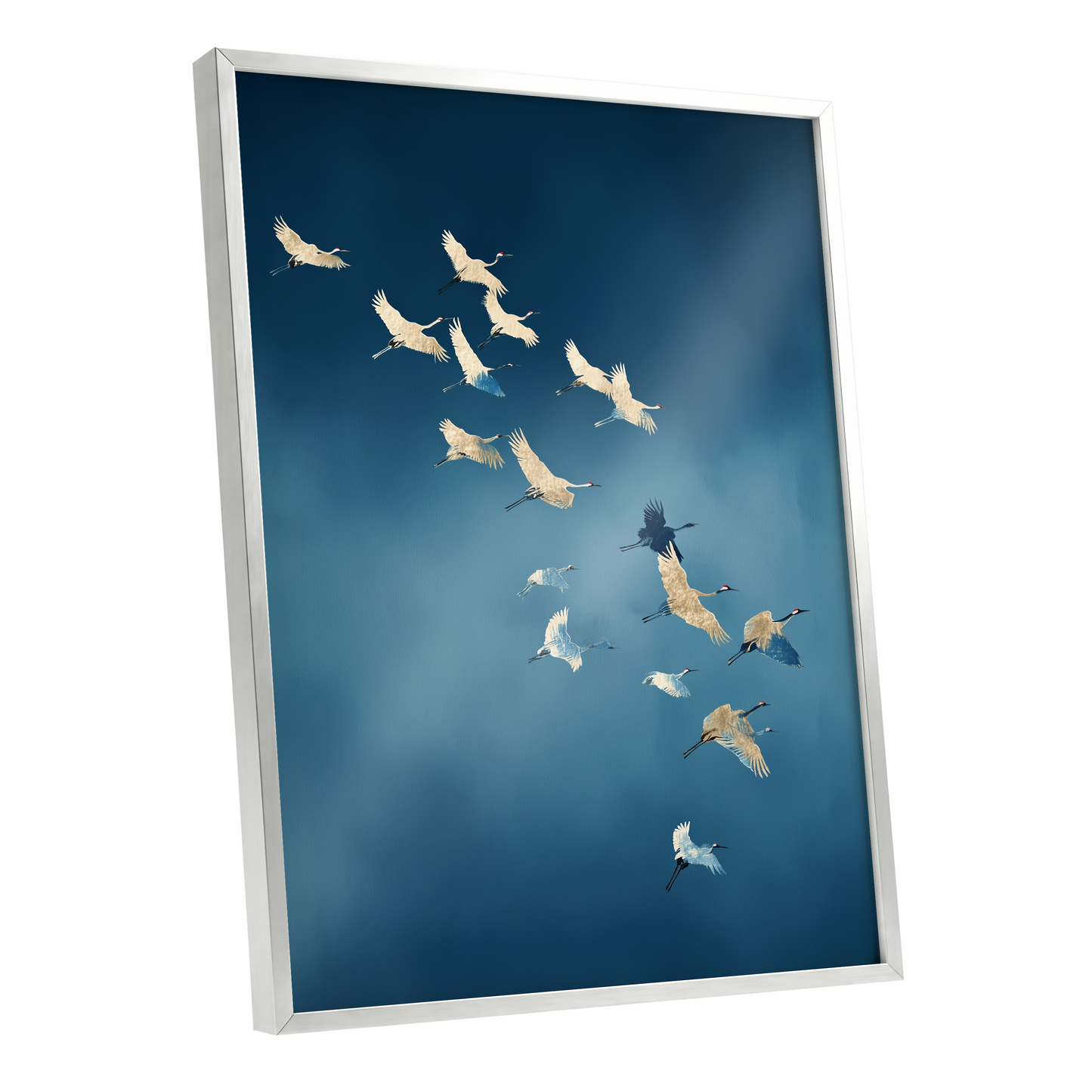 A framed wall art print showing a flock of cranes flying across a deep blue sky, displayed at an angle against a clean white background.