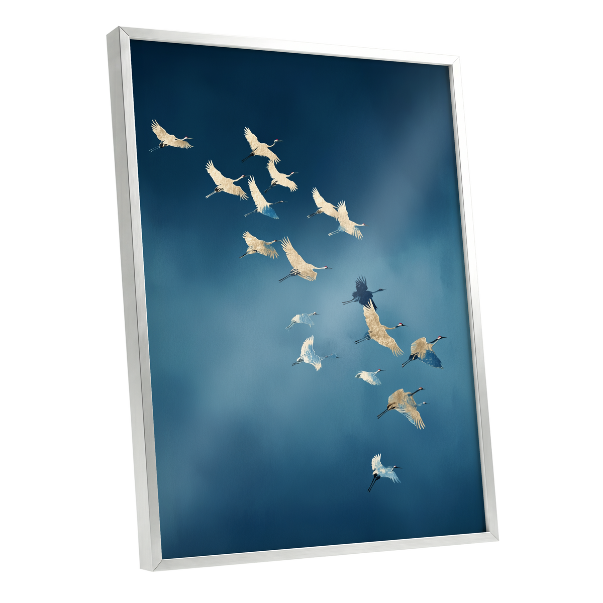 A framed wall art print showing a flock of cranes flying across a deep blue sky, displayed at an angle against a clean white background.