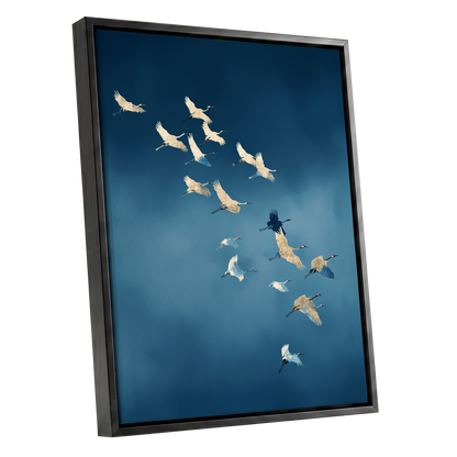 Framed wall art featuring a flock of cranes flying across a deep blue sky, shown in a black frame against a plain white background.