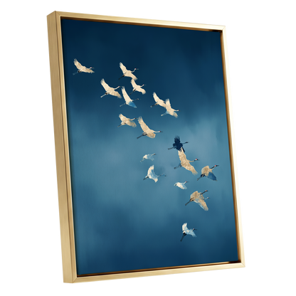 A framed wall art print showing a flock of cranes flying across a deep blue sky, presented in a gold frame against a white background.