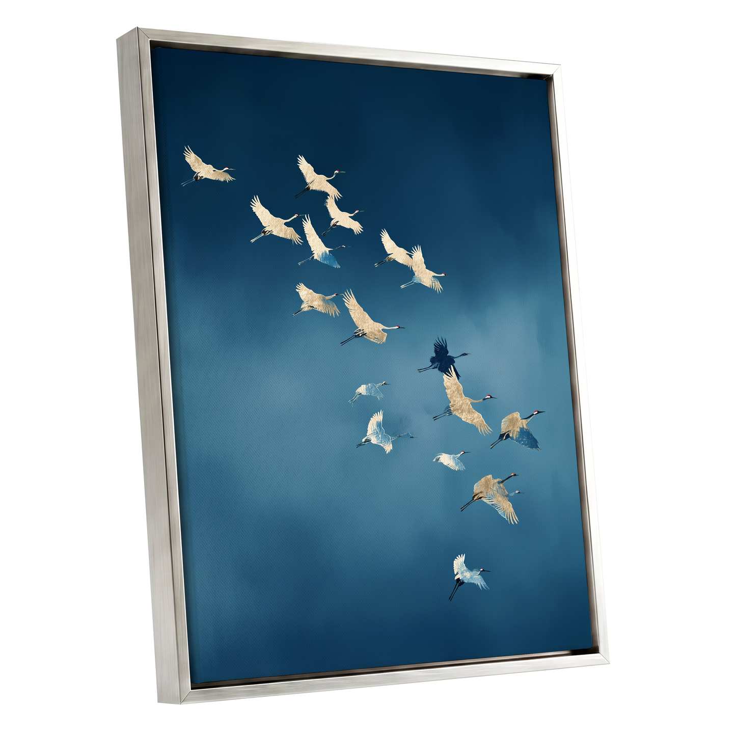A framed wall art print showing a flock of cranes flying across a deep blue sky, presented at an angle with a silver frame on a white background.
