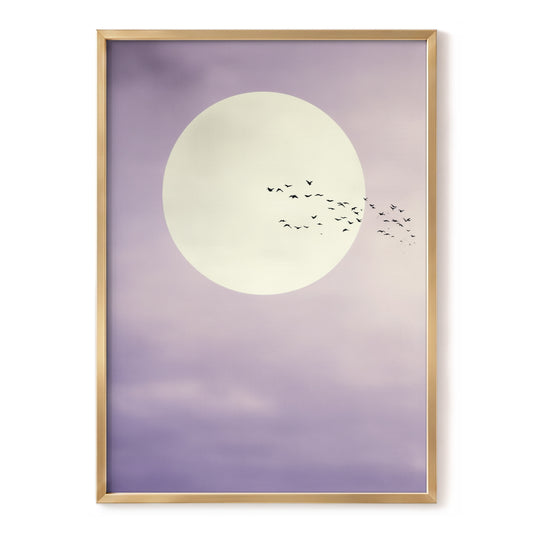 A framed art print featuring a large cream-colored moon and a flock of small black birds against a soft lavender-purple sky, enclosed in a thin gold frame.