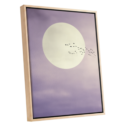 Framed wall art featuring a large cream moon and a flock of birds against a soft lavender-purple sky, shown in a light natural wood frame on a white background.
