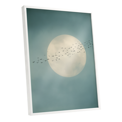 Framed wall art featuring a large cream-colored full moon against a muted teal-blue sky with a flock of birds flying across it, shown in a white floating frame on a white background.