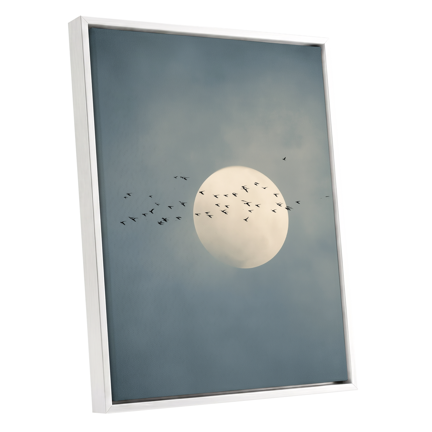 Framed wall art featuring a pale full moon against a muted blue-gray cloudy sky, with small black bird silhouettes flying around it. The artwork is shown in a white frame on a plain white background.