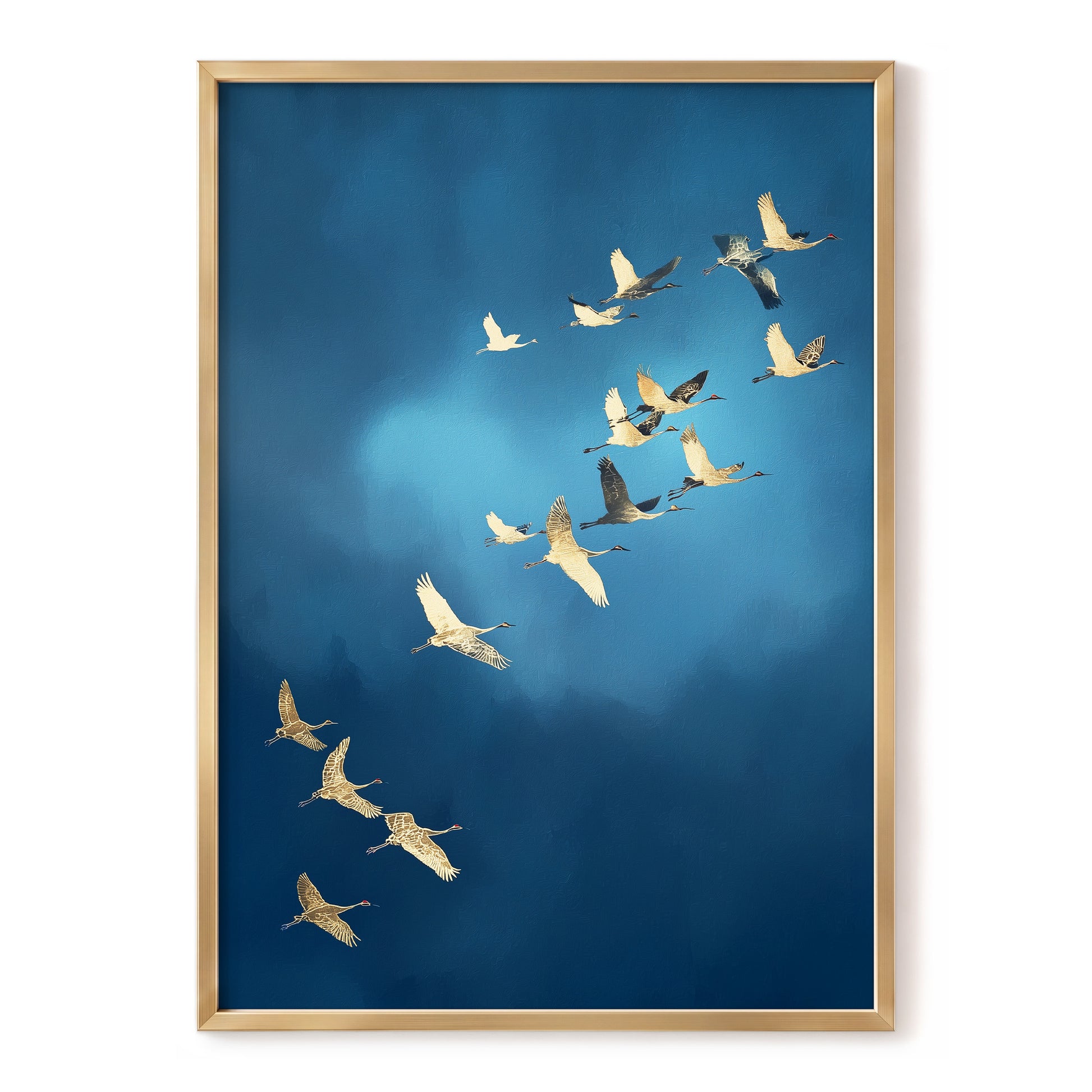 Framed wall art featuring a flock of cranes flying across a deep blue sky, presented in a light natural wood frame against a white background.