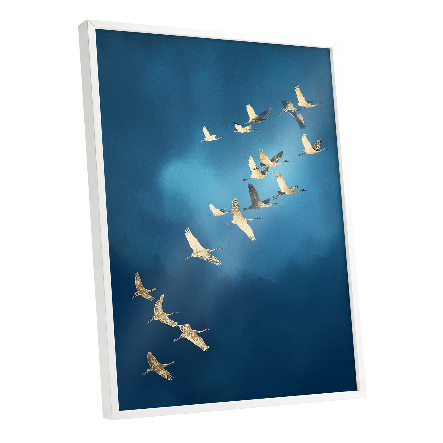 A framed wall art print showing a flock of cranes flying across a deep blue sky, displayed at an angle with a white frame against a clean white background.