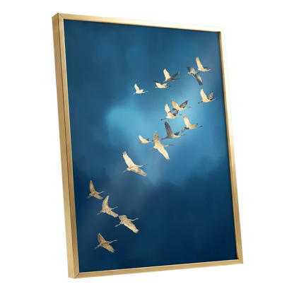 Framed wall art featuring a flock of white cranes flying across a deep blue sky, shown in a gold frame against a white background.