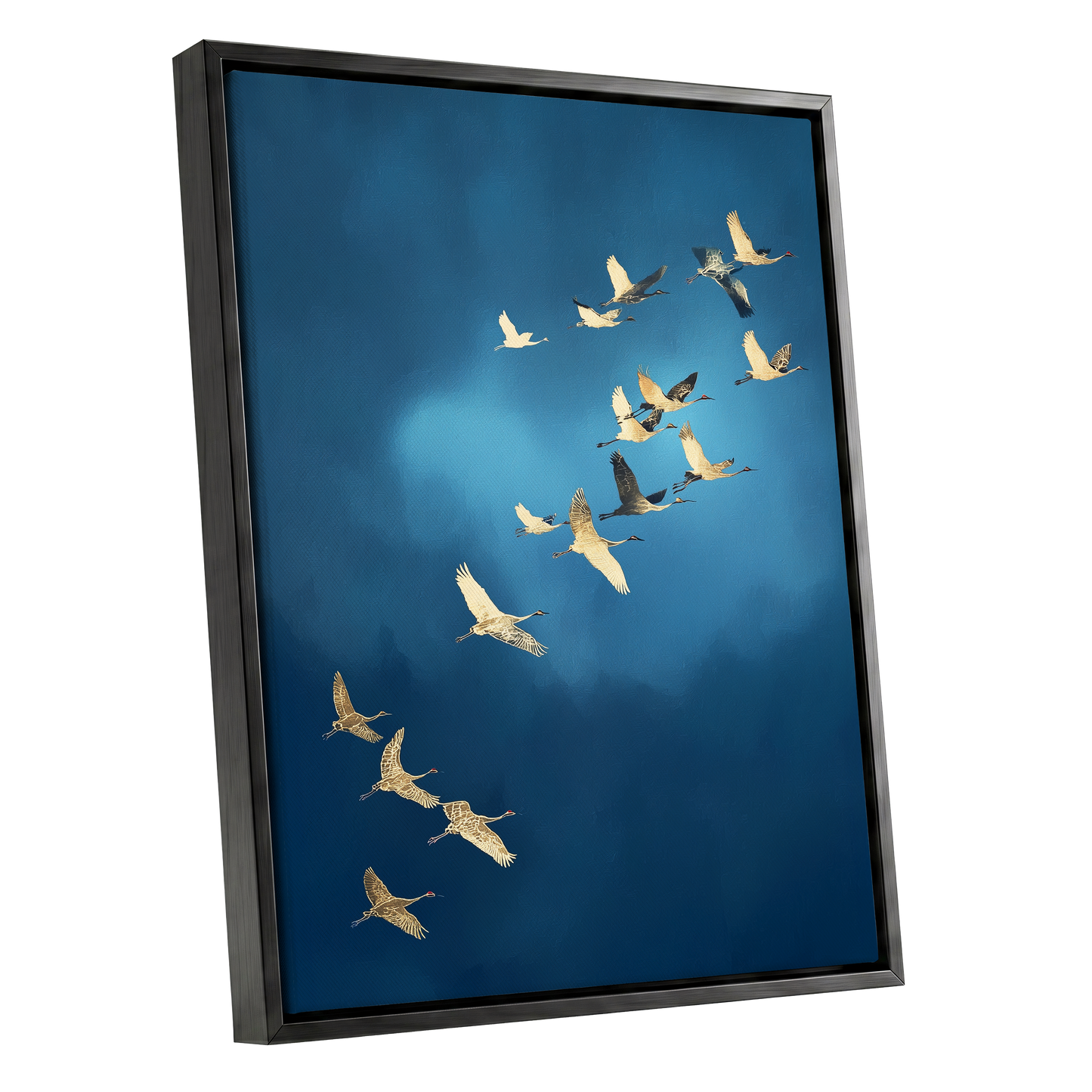 A framed wall art print showing a flock of cranes flying across a deep blue sky, presented at an angle with a black frame on a white background.