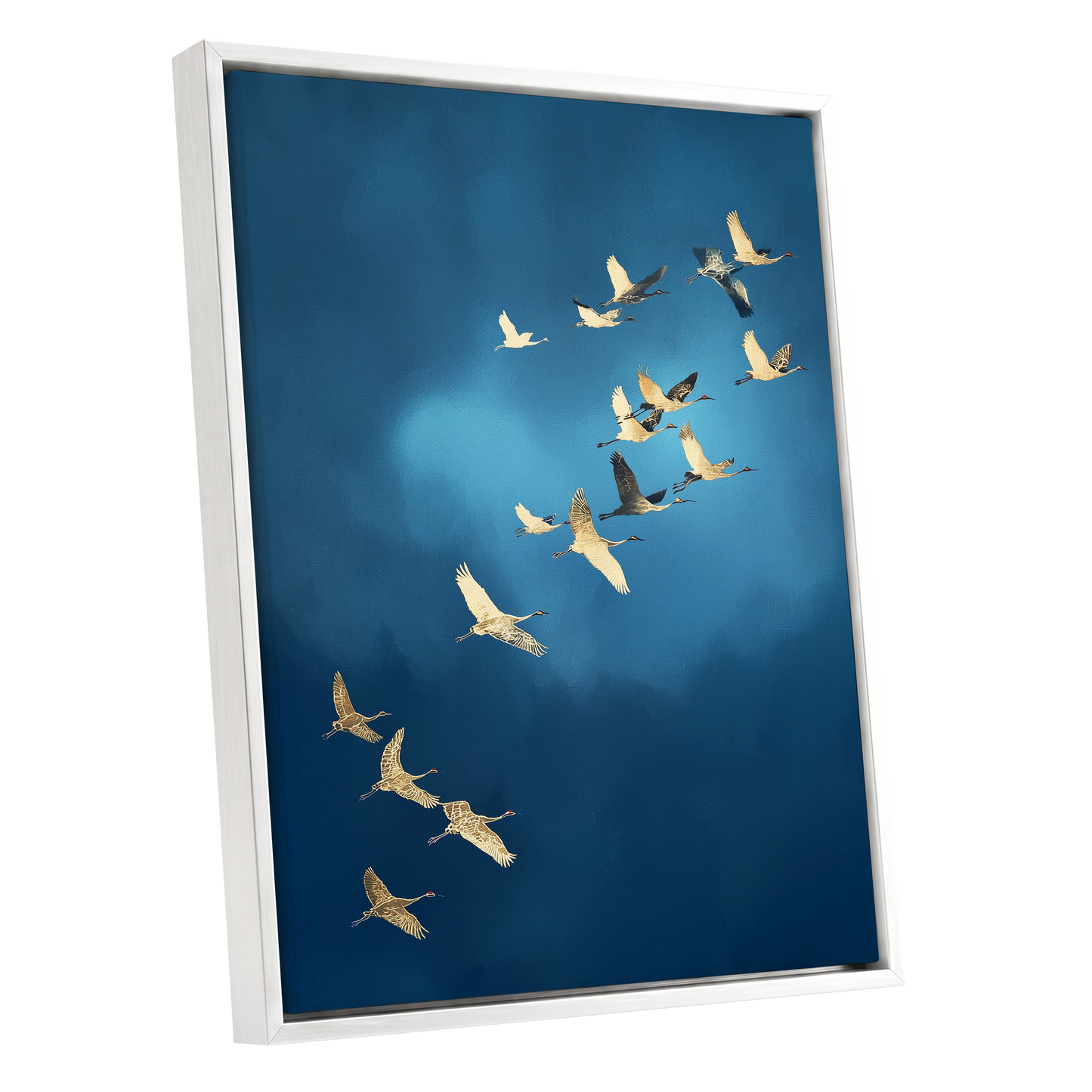 A framed wall art print showing a flock of cranes flying across a deep blue sky, presented at an angle against a plain white background.