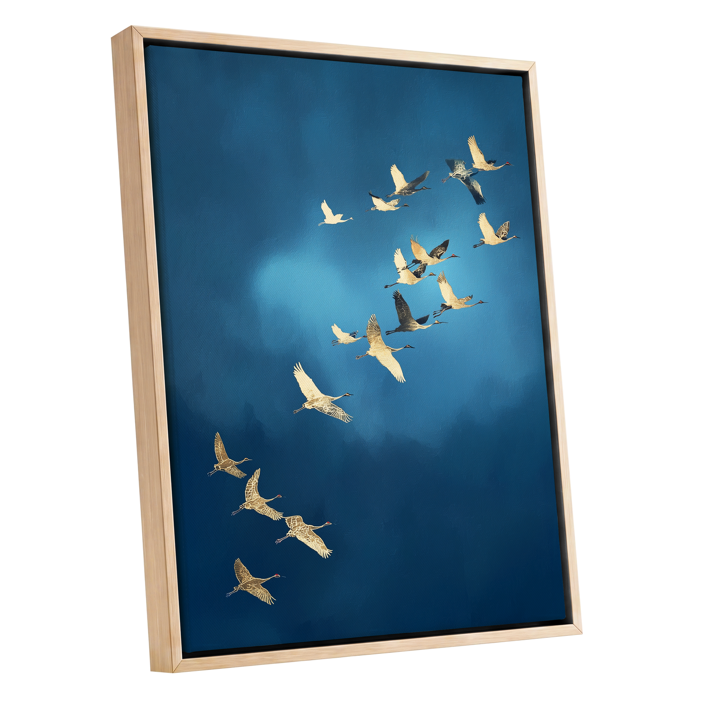 Framed wall art featuring a flock of cranes flying diagonally across a deep blue sky, shown in a light natural wood frame against a white background.