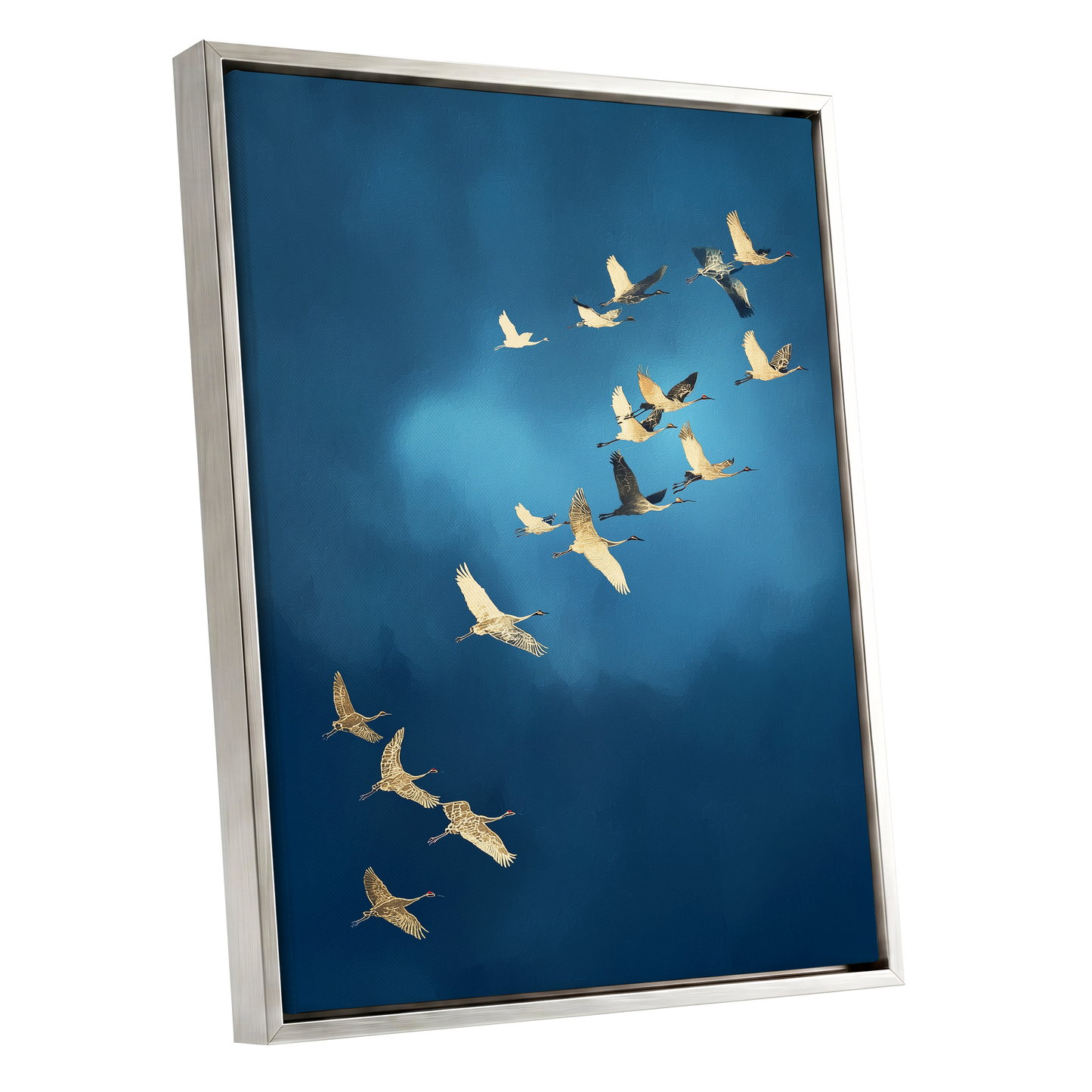 A framed wall art print showing a flock of cranes flying across a deep blue sky, presented in a brushed silver frame against a white background.