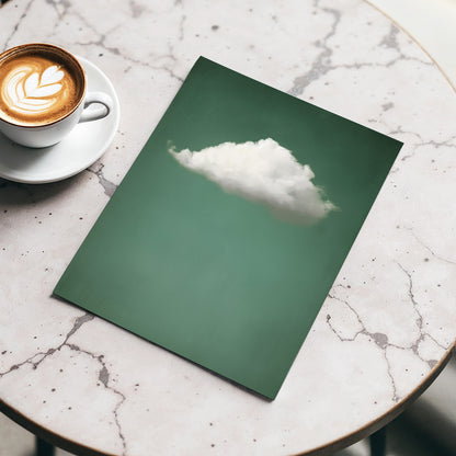 Green notebook with a cloud illustration on a marble surface next to a cup of coffee.