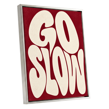 Go Slow Ruby, red, beige abstract wall art shown as a silver framed canvas wall art