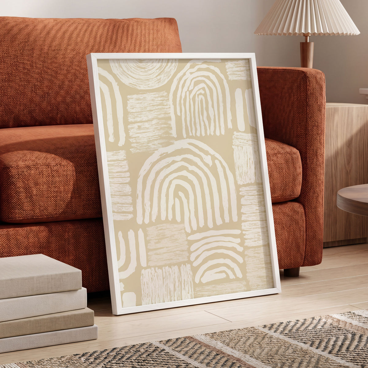 Neutral Boho Arches: a framed abstract art print with cream arches and textured vertical strokes on a warm beige background, leaning against an orange-brown sofa in a modern living room setting.